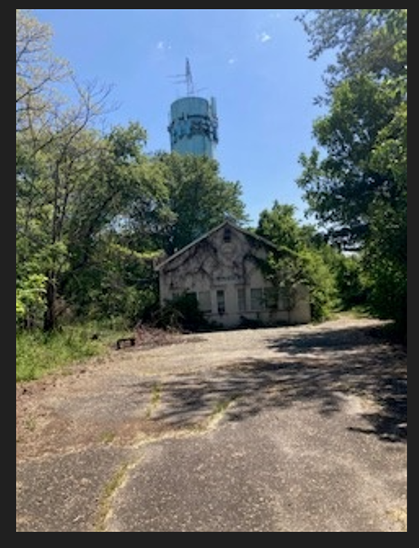 Photo of cell tower, with existing building in the forefront