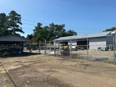 View of fenced in area with warehouse