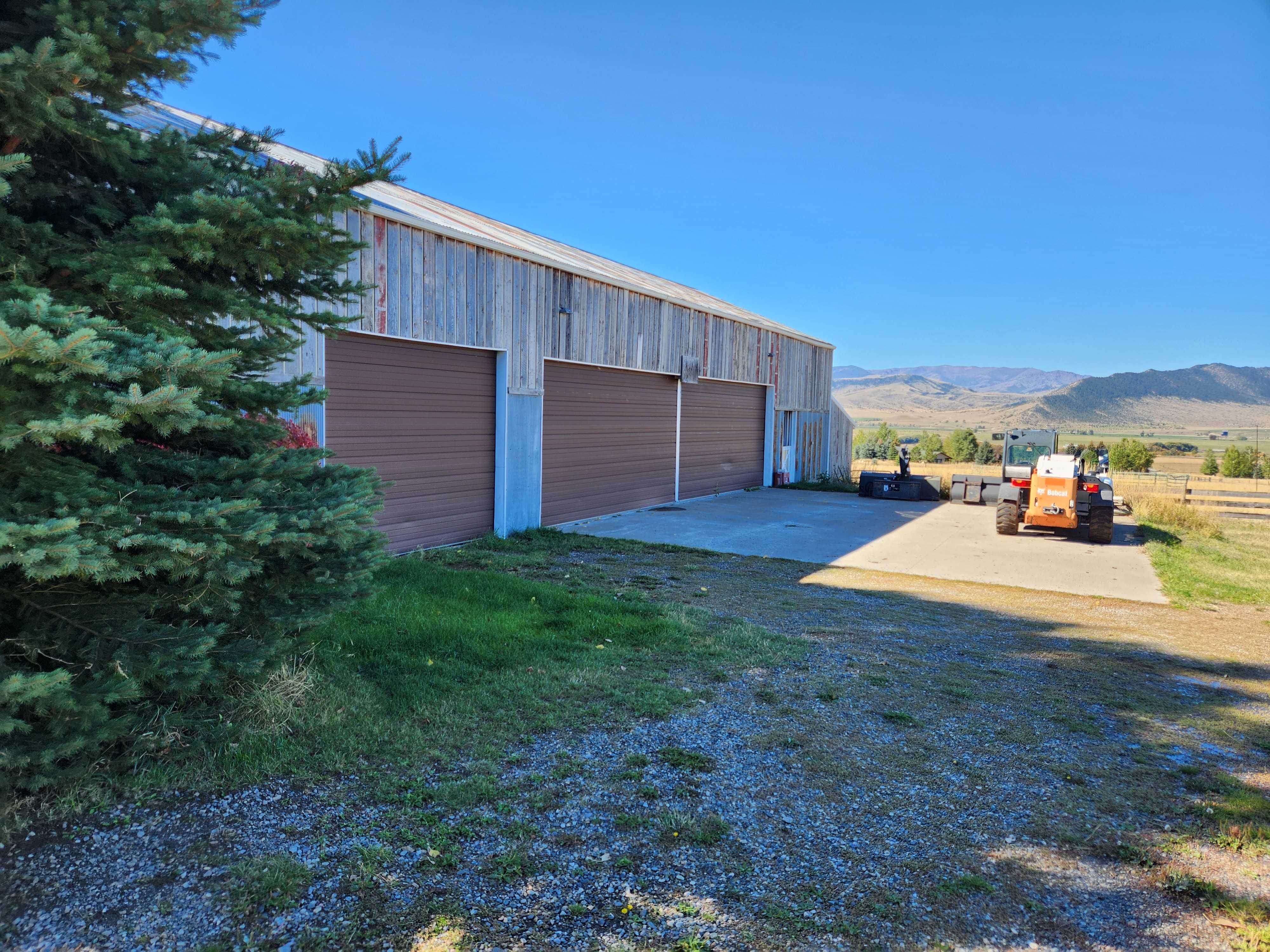 Side view of garage showing 3 garage doors and concrete slab