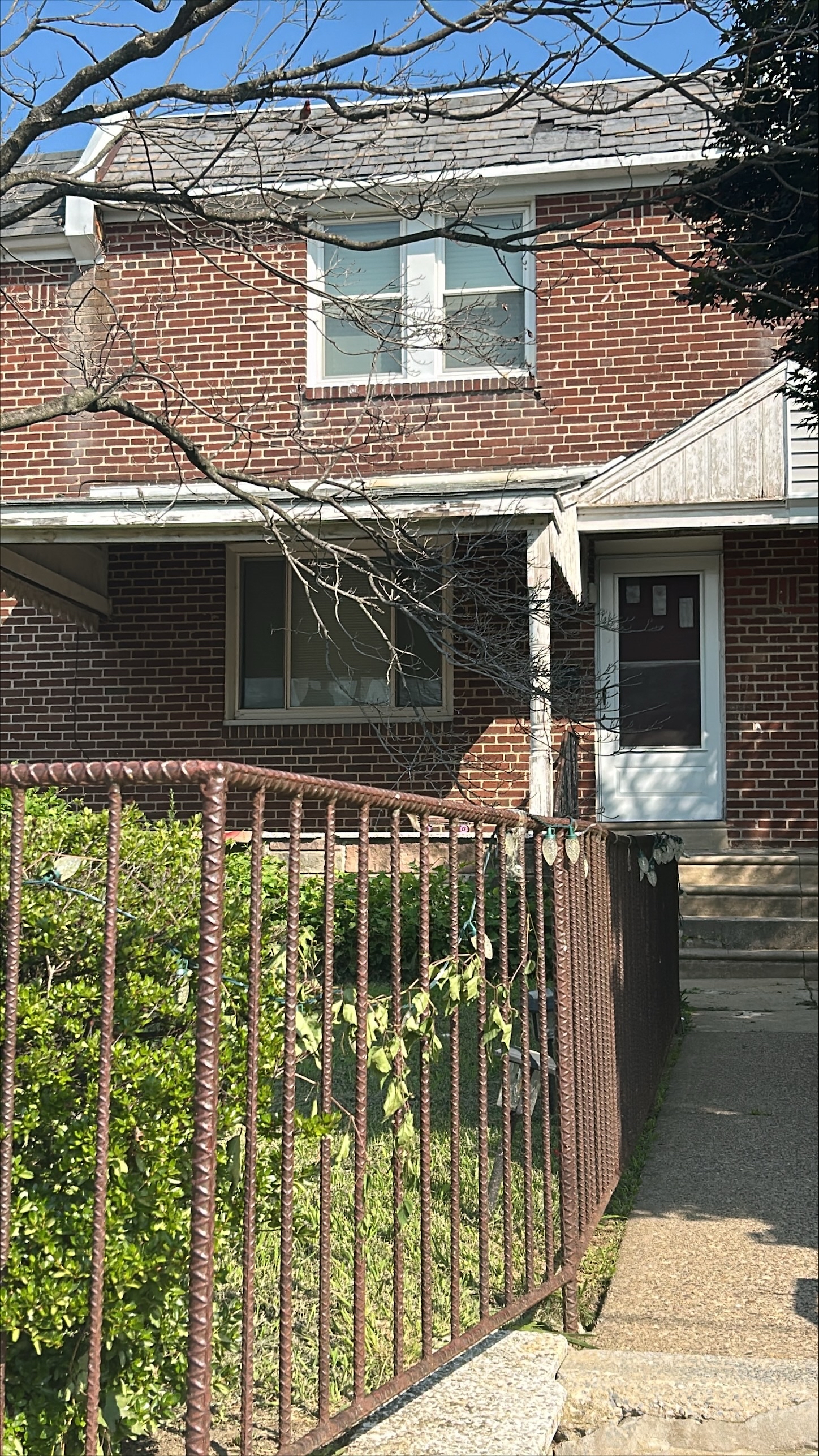 Sidewalk to front door and iron fence around front yard