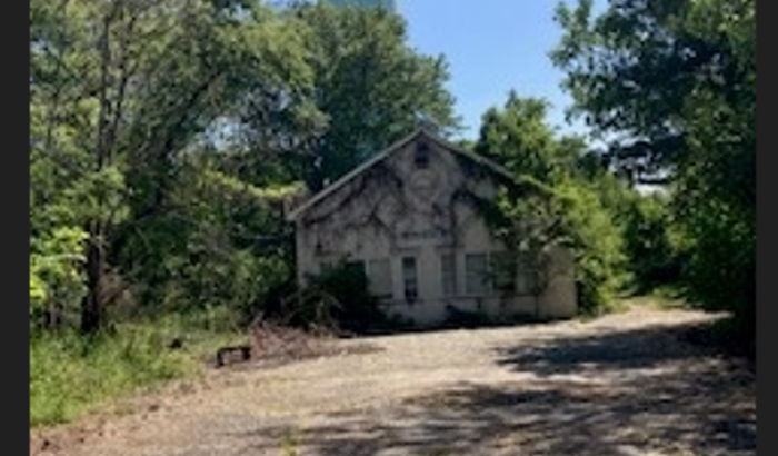 Photo of cell tower, with existing building in the forefront