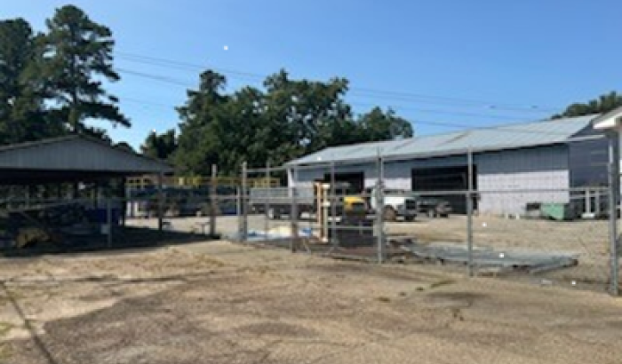 View of fenced in area with warehouse